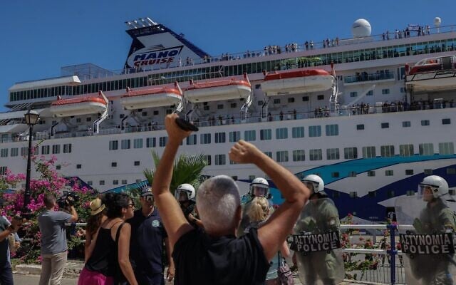 Des forces antiémeutes grecques montant la garde alors que des manifestants anti-Israël protestant contre l'arrivée du « Crown Iris », un paquebot transportant des touristes israéliens, à Agios Nikolaos, sur l'île de Crète, le 29 juillet 2025. (Crédit : Costas Metaxakis/AFP)