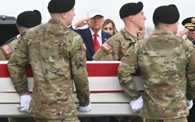 Le président américain Donald Trump saluant tandis que des membres d’une équipe de l’armée américaine transportent un cercueil recouvert du drapeau américain contenant la dépouille du sergent-chef Noah L. Tietjens, lors d’une cérémonie solennelle de transfert à la base aérienne de Dover, à Dover, dans le Delaware, le 7 mars 2026. (Crédit : Saul Loeb/AFP)