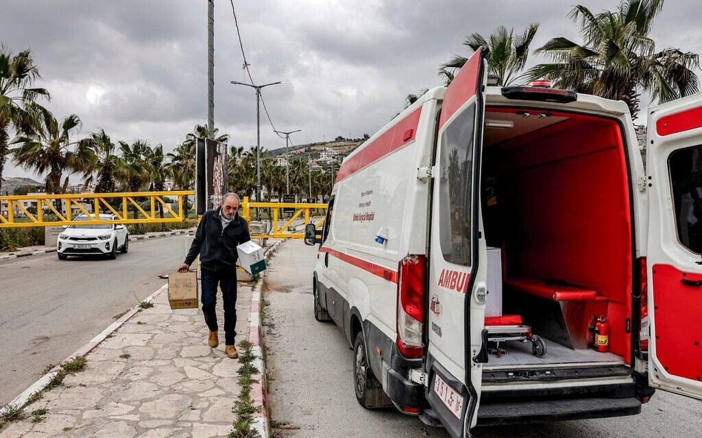 Illustration : Un homme transportant des cartons de médicaments depuis l'hôpital Rafidiya de Naplouse vers une ambulance qui attend derrière un barrage à l'entrée du village de Turmus Ayya, en Cisjordanie, le 6 mai 2026. (Crédit : Zain Jaafar/AFP)