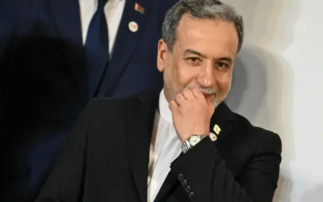 Le ministre iranien des Affaires étrangères, Abbas Araghchi, fait un geste à son arrivée pour une photo de groupe lors de la réunion des ministres des Affaires étrangères des pays du BRICS au Bharat Mandapam à New Delhi, le 14 mai 2026. (Crédit: Arun SANKAR / AFP)