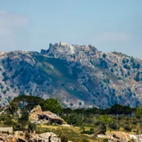 Cette photo prise depuis une position dans la région de la Haute-Galilée, dans le nord d'Israël, donne à voir des bâtiments détruits dans le village libanais de Kfar Kila (au sud) et le château médiéval de Beaufort en arrière-plan, à la suite d'une frappe aérienne israélienne le 31 mai 2026. (Jalaa MAREY / AFP)