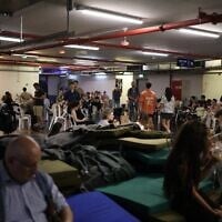 Des personnes s'abritant dans un parking souterrain lors d'une alerte  aux missiles, à Tel Aviv, le 8 juin 2026 (Crédit : Ilia Yefimovich/AFP)