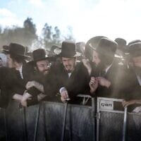 Les forces de sécurité montent la garde alors que des juifs ultra-orthodoxes se rassemblent pour manifester contre la détention de réfractaires haredim devant la prison militaire de Bet Lid, à Kfar Yona, le 17 juin 2026. (Crédit : Ilia Yefimovich/AFP)
