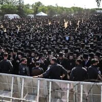 Les forces de sécurité israéliennes montant la garde alors que des Juifs ultra-orthodoxes se rassemblent pour protester contre la détention de réfractaires haredim devant la prison militaire de Bet Lid, à Kfar Yona, le 17 juin 2026. (Crédit : Ilia Yefimovich/AFP)