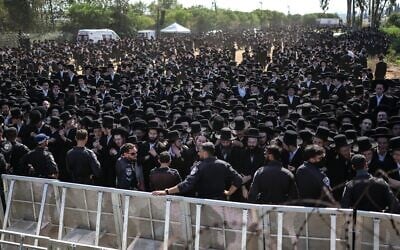 Les forces de sécurité israéliennes montant la garde alors que des Juifs ultra-orthodoxes se rassemblent pour protester contre la détention de réfractaires haredim devant la prison militaire de Bet Lid, à Kfar Yona, le 17 juin 2026. (Crédit : Ilia Yefimovich/AFP)