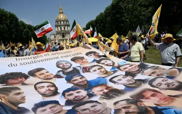 Des manifestants brandissant une banderole géante sur laquelle figurent les portraits de ressortissants iraniens disparus, lors d’une manifestation non autorisée organisée par des associations franco-iraniennes, près de la place Vauban, dans le centre de Paris, le 20 juin 2026. (Crédit : Arnaud Finistre/AFP)