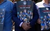 Des journalistes palestiniens tenant des pancartes à l’effigie de leurs présumés collègues tués pendant la guerre à Gaza, sur lesquelles on peut lire « Arrêtez le génocide médiatique, le journalisme n’est pas un crime », lors d’un rassemblement organisé pour commémorer le deuxième anniversaire de la guerre à Gaza, devant le bureau des Nations unies, à Ramallah, en Cisjordanie, le 8 octobre 2025. (Crédit : Nasser Nasser/AP)