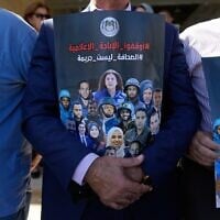Des journalistes palestiniens tenant des pancartes à l’effigie de leurs présumés collègues tués pendant la guerre à Gaza, sur lesquelles on peut lire « Arrêtez le génocide médiatique, le journalisme n’est pas un crime », lors d’un rassemblement organisé pour commémorer le deuxième anniversaire de la guerre à Gaza, devant le bureau des Nations unies, à Ramallah, en Cisjordanie, le 8 octobre 2025. (Crédit : Nasser Nasser/AP)