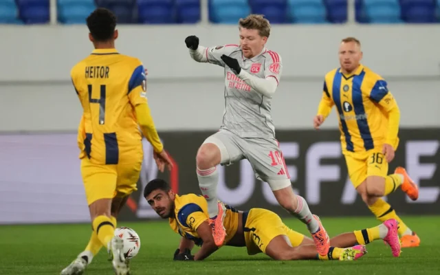 Raz Shlomo, du Maccabi Tel Aviv, au centre, lutte pour le ballon avec Pavel Sulc de Lyon, au sol, lors du match de football de la phase de ligue de l'Europa League entre le Maccabi Tel Aviv et Lyon, à Backa Topola, en Serbie, le 27 novembre 2025. (AP Photo/Darko Vojinovic)