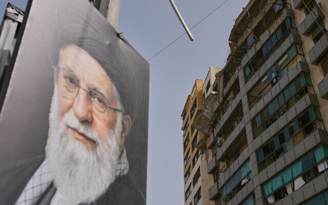 Un portrait de l’ayatollah Ali Khamenei, défunt guide suprême de l’Iran, près d’un bâtiment endommagé lors d’une frappe aérienne israélienne dans la banlieue sud de Beyrouth - bastion historique du groupe terroriste chiite libanais du Hezbollah connu sous le nom de la Dahiyeh -, le 4 avril 2026. (Crédit : Bilal Hussein/AP Photo)