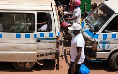 Un homme portant un masque de protection, dans une rue animée de Kampala, en Ouganda, le 19 mai 2026. (Crédit : Hajarah Nalwadda/AP)