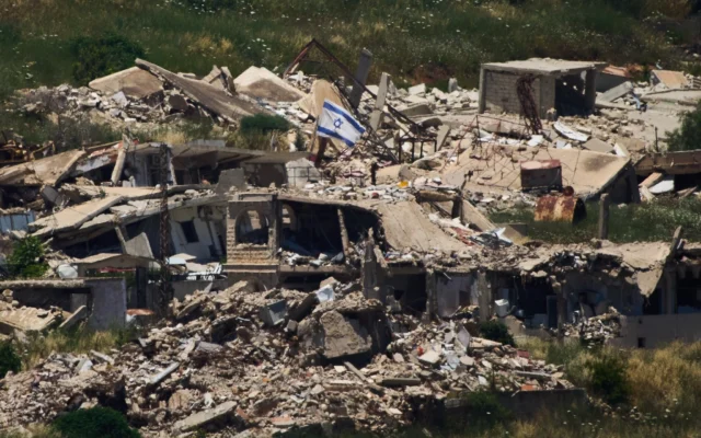 Un drapeau israélien flotte sur un bâtiment détruit dans le sud du Liban, vu depuis le nord d'Israël, le 4 juin 2026. (Crédit: AP/Ariel Schalit)