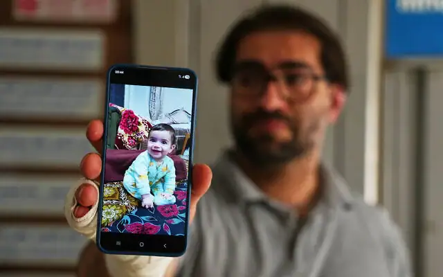 Fahd Abou Haikal, 41 ans, montre la photo de son fils de 7 mois, Sam, tué la veille, dans un hôpital d'Hébron le 6 juin 2026, un jour après que le bébé a été tué par Tsahal dans cette ville du sud de la Cisjordanie. Tsahal a fait part de son 
« profond regret » suite à cet incident. (Photo AP / Mahmoud Illean)
