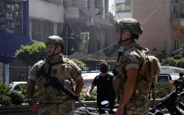 Des soldats libanais montent la garde à l'endroit d'une frappe aérienne israélienne qui a touché un appartement à Dahiyeh, dans la banlieue sud de Beyrouth, au Liban, le 14 juin 2026. (Photo AP/Bilal Hussein)