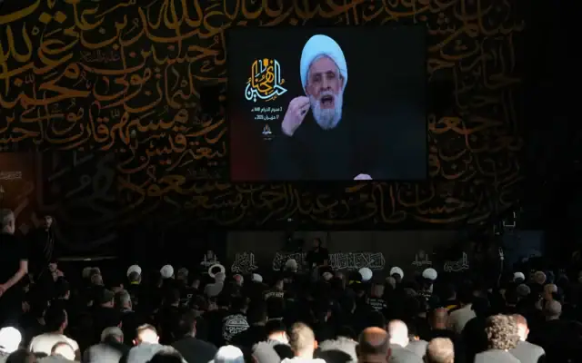 Le chef du Hezbollah, le cheikh Naim Qassem, apparaît sur un écran lors d'un sermon marquant le premier jour de l'Achoura, devant la tombe de l'ancien chef du Hezbollah, Sayyed Hassan Nasrallah (à gauche), à Beyrouth, au Liban, le 17 juin 2026. ( Crédit: AP/Hussein Malla)
