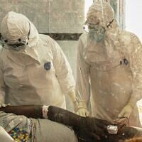 Des professionnels de santé s'occupant d'un patient atteint d'Ebola au centre de traitement de Rwampara, en Ituri, au Congo, le 18 juin 2026. (Crédit : Moses Sawasawa/AP)