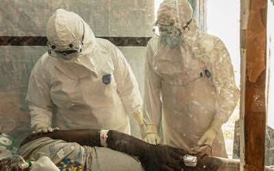 Des professionnels de santé s'occupant d'un patient atteint d'Ebola au centre de traitement de Rwampara, en Ituri, au Congo, le 18 juin 2026. (Crédit : Moses Sawasawa/AP)