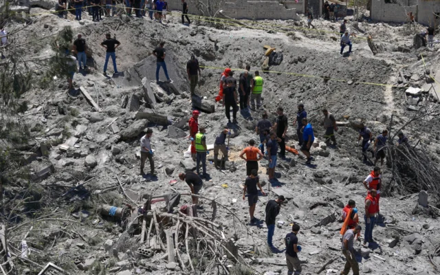 Les secouristes et la population recherchant des survivants sous les décombres d’un bâtiment détruit, touché par une frappe aérienne israélienne dans le village de Qannarit, au sud du Liban, le 20 juin 2026. (Crédit : Mohammed Zaatari/AP)