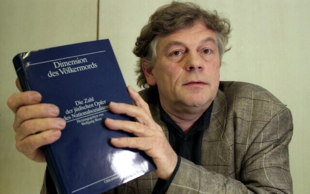 L'éditeur Wolfgang Benz présente son ouvrage « Dimension Of The Genocide », le lundi 10 juin 1991 à Munich, en Allemagne. (Crédit : AP Photo/Arne Dedert)