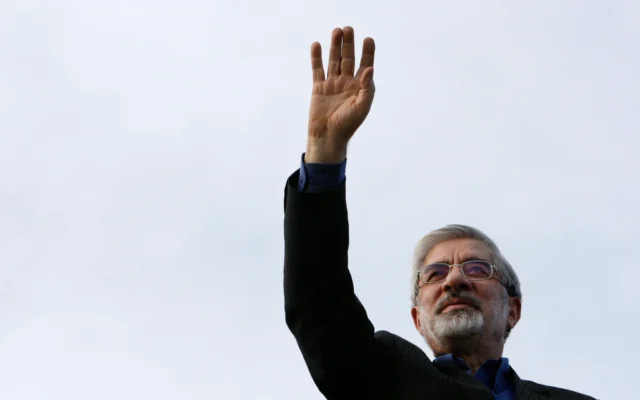 Mir Hossein Mousavi salue ses partisans à son arrivée à un rassemblement électoral dans le centre-ville de Téhéran, en Iran, le 8 juin 2009. (Crédit: AP/Vahid Salemi)