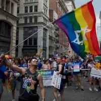 Dillon Perez agite un drapeau de la fierté juive lors de la Marche des fiertés de New York, le 29 juin 2026. (Grace Gilson/JTA)