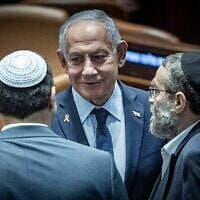 Le Premier ministre Benjamin Netanyahu (au centre) et Moshe Gafni, député de Yahadout HaTorah (à droite), dans l'hémicycle de la Knesset, à Jérusalem, le 19 mars 2025. (Crédit : Yonatan Sindel/Flash90)