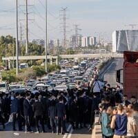 Des manifestants bloquant la circulation pour protester contre l'arrestation de réfractaires ultra-orthodoxes, sur la Route 4, près de l'échangeur de Ganot, dans le centre d'Israël, le 1ᵉʳ juin 2026. (Crédit : Chaïm Goldberg/Flash90)