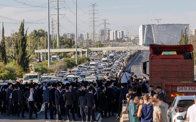 Des manifestants haredim bloquant la circulation pour protester contre l'arrestation de réfractaires ultra-orthodoxes, sur la Route 4, près de l'échangeur de Ganot, dans le centre d'Israël, le 1ᵉʳ juin 2026. (Crédit : Chaïm Goldberg/Flash90)