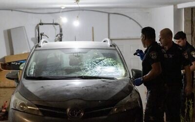 La police inspectant une voiture endommagée devant le domicile du vice-président de la Cour suprême, Noam Sohlberg, dans l'implantation d'Alon Shvut en Cisjordanie, après que des Haredim ont attaqué la maison pour protester contre l'incarcération de ceux qui n'ont pas respecté les ordres de conscription de l'armée israélienne, le 3 juin 2026. (Crédit : Chaïm Goldberg/Flash90)
