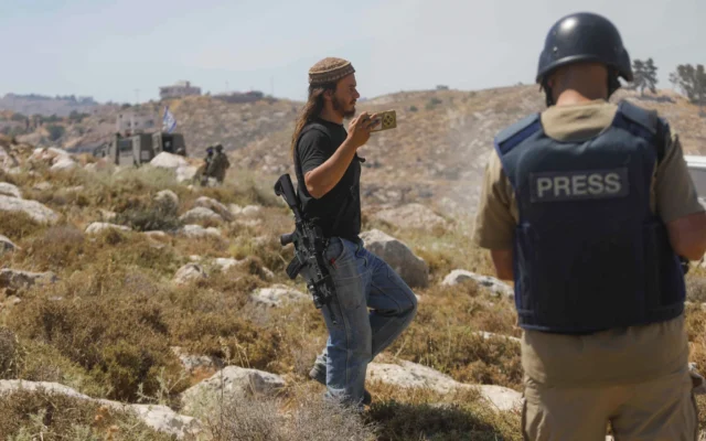 Photo d'Illustration : un résident d'implantation israélien filme les affrontements entre les forces de sécurité et les Palestiniens lors d’une manifestation à Khirbet Humsa, à l’ouest d’Hébron en Cisjordanie, le 9 juin 2026. (Crédit: Wisam Hashlamoun/Flash90)