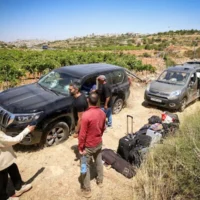 Des personnes évaluent les dégâts causés à des véhicules palestiniens par des résidents d'implantations violents qui s'en sont pris à un groupe de Palestiniens et de militants juifs près de Halhul, dans les environs d'Hébron en Cisjordanie, le 15 juin 2026. (Wisam Hashlamoun/Flash90)