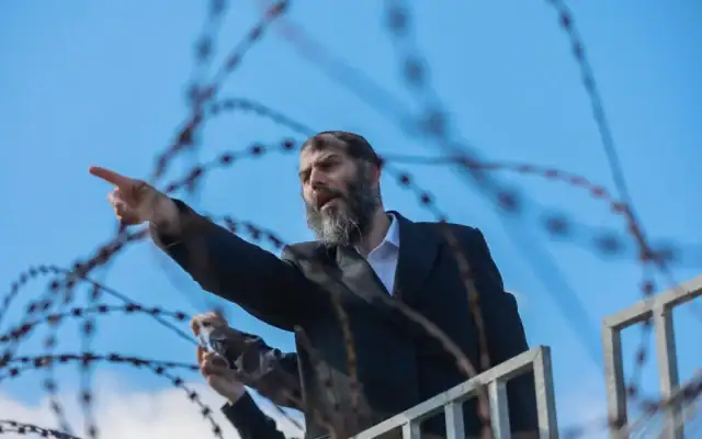 Motti Babchik, un haut responsable politique du parti Yahadout HaTorah, et des milliers d'hommes juifs ultra-orthodoxes manifestent devant une prison militaire israélienne près de Kfar Yona, dans le centre d'Israël, contre l'incarcération d'étudiants de yeshiva qui n'ont pas respecté les termes de leur ordre de mobilisation, le 17 juin 2026. (Tal Gal/Flash90)