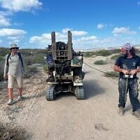 Gilad Shtienberg, à gauche, et un autre chercheur transportent le géotube jusqu'à l'emplacement prévu dans l'ancienne zone humide de Kebara, sur la côte du Carmel, au nord d'Israël. (Autorisation : Tom Levy)