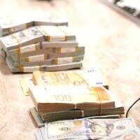 De l'argent saisi par la police lors d'une série de perquisitions menées à Nahariya, au cours desquelles 14 personnes ont été arrêtées, soupçonnées d'avoir participé à un réseau de corruption, le 2 juin 2026. (Crédit : Police israélienne)
