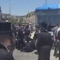 Des Haredim bloquant un bus au poste de contrôle des Tunnels, situé entre le sud de Jérusalem et la Cisjordanie, à la suite de l'arrestation d'un individu soupçonné d'avoir participé à une émeute contre la conscription devant le domicile du juge de la Cour suprême Noam Sohlberg, le 7 juin 2026. (Crédit : Capture d'écran/Moshe Zaide/ZiratNews via X)
