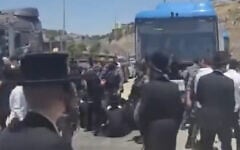 Des Haredim bloquant un bus au poste de contrôle des Tunnels, situé entre le sud de Jérusalem et la Cisjordanie, à la suite de l'arrestation d'un individu soupçonné d'avoir participé à une émeute contre la conscription devant le domicile du juge de la Cour suprême Noam Sohlberg, le 7 juin 2026. (Crédit : Capture d'écran/Moshe Zaide/ZiratNews via X)