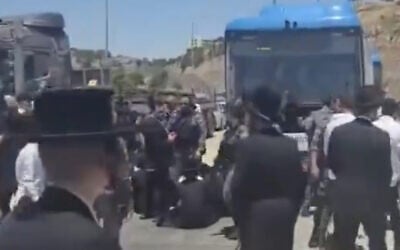 Des Haredim bloquant un bus au poste de contrôle des Tunnels, situé entre le sud de Jérusalem et la Cisjordanie, à la suite de l'arrestation d'un individu soupçonné d'avoir participé à une émeute contre la conscription devant le domicile du juge de la Cour suprême Noam Sohlberg, le 7 juin 2026. (Crédit : Capture d'écran/Moshe Zaide/ZiratNews via X)