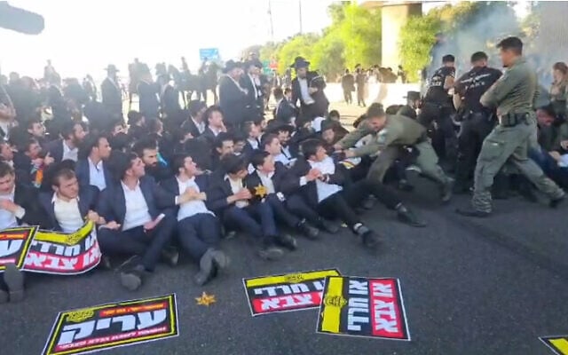 La police affronte des manifestants ultra-orthodoxes, dont certains portent des étoiles jaunes rappelant celles imposées aux Juifs pendant la Shoah, lors d’une manifestation haredi contre le service militaire à l’échangeur de Ben Shemen, dans le centre d’Israël, le 11 juin 2026. (Crédit : Police israélienne)