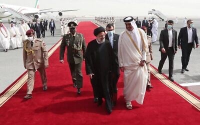 Le président iranien Ebrahim Raissi accueilli par l'émir du Qatar Tamim ben Hamad al-Thani, à son arrivée à Doha, au Qatar, le 21 février 2022. (Crédit : Présidence iranienne via AP)