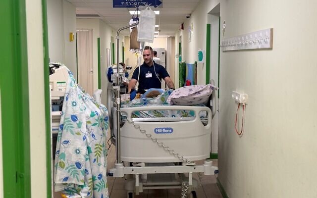 Un membre du personnel de l'hôpital de Nahariya ramenant un patient dans un service en surface, le 3 juin 2026. (Crédit : Shelli Chaika/Hôpital de Nahariya)