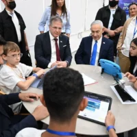 Le ministre de l'Éducation, Yoav Kisch, et le Premier ministre Benjamin Netanyahu avec des élèves du collège Dekel Vilnai dans l'implantation de Maale Adumim, en Cisjordanie, pour le lancement d'un programme d'apprentissage de l'anglais via l'IA, le 11 juin 2026. (Haim Zach / GPO)