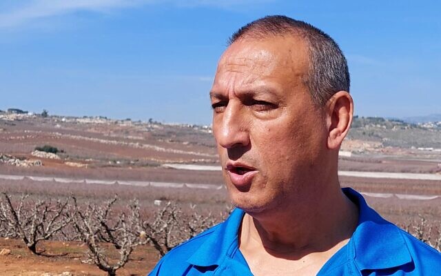 Le maire de Metula, David Azoulay, se tient à l’entrée de la ville, d’où l’on aperçoit le village de Kfar Kila, au sud du Liban, un bastion du Hezbollah, deux heures après le retrait de l’armée israélienne du Liban, le 17 février 2025. (Crédit: Lindy Barnett/Autorisationà