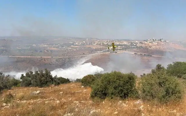 Un avion bombardier d'eau israélien largue du retardant sur un feu de forêt dans le nord de la Cisjordanie, le 28 juin 2026. (Service de sécurité incendie et de sauvetage)