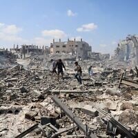 Des Gazaouis inspectant le site d'une frappe israélienne sur un entrepôt dont l'évacuation avait été ordonnée par l'armée israélienne avant la frappe, à Gaza-City, le 27 juillet 2026. (Crédit : Ebrahim Hajjaj/Reuters)