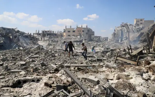 Des Palestiniens inspectent le site d’une frappe israélienne sur un entrepôt dont l’évacuation avait été ordonnée par l’armée israélienne avant l’attaque, à Gaza, le 27 juillet 2026. (Crédit: Ebrahim Hajjaj/Reuters)