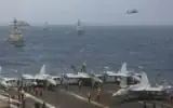 Des navires de guerre et des avions de la Marine américaine naviguant en formation serrée dans la mer d'Oman, sur une photo publiée le 8 juillet 2026. (Crédit : Marine américaine)