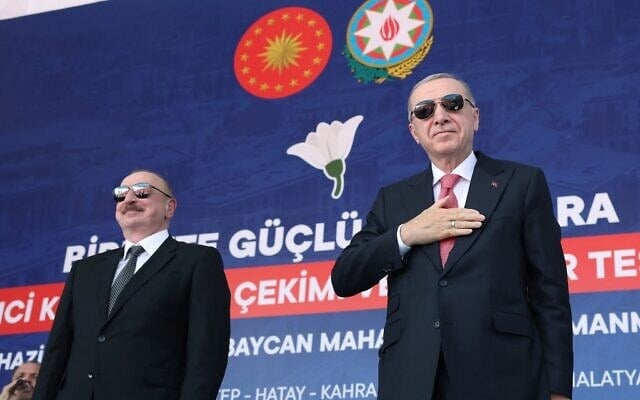 Le président turc Recep Tayyip Erdogan (à droite) et le président azerbaïdjanais Ilham Aliyev (à gauche) saluant leurs partisans lors de la cérémonie d’inauguration des 250 000 logements construits après le séisme, à Kahramanmaras, sur cette photo diffusée le 19 juin 2025. (Crédit : Service de presse de la présidence turque/AFP)