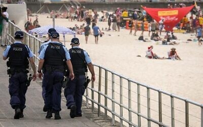 Des policiers patrouillent près des baigneurs le jour de Noël à Bondi Beach, à Sydney, le 25 décembre 2025. (Crédit : David Gray/AFP) Des policiers patrouillent près des baigneurs le jour de Noël à Bondi Beach, à Sydney, le 25 décembre 2025. (Crédit : David Gray/AFP)