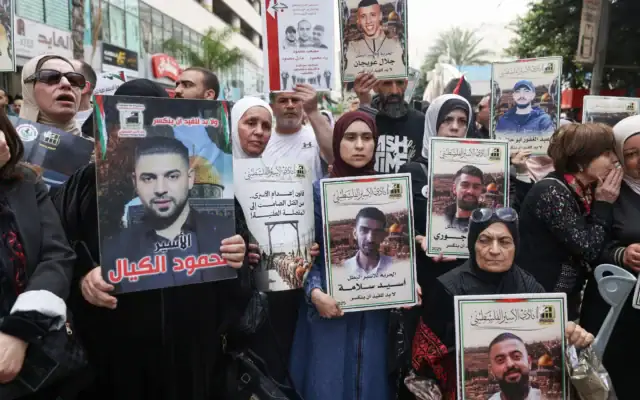 Des manifestants palestiniens brandissent des photos de Palestiniens emprisonnés lors d’un rassemblement à Ramallah, en Cisjordanie, le 19 avril 2026, pour marquer la Journée des prisonniers et protester contre l’adoption par la Knesset d’un nouveau projet de loi instaurant la peine de mort pour les Palestiniens reconnus coupables d’attaques meurtrières. (Crédit: JAAFAR ASHTIYEH / AFP)