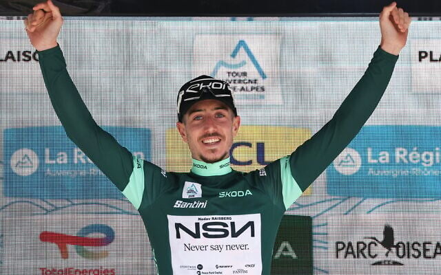 Nadav Raisberg, coureur israélien de l'équipe cycliste NSN, sur le podium, vêtu du maillot vert du meilleur sprinteur, à l'issue de la 8e et dernière étape du Tour Auvergne-Rhône-Alpes, dans les Alpes françaises, le 14 juin 2026. (Crédit : Anne-Christine POUJOULAT / AFP)